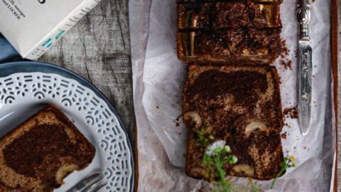 banana bread on baking paper on a brown wooden tablet