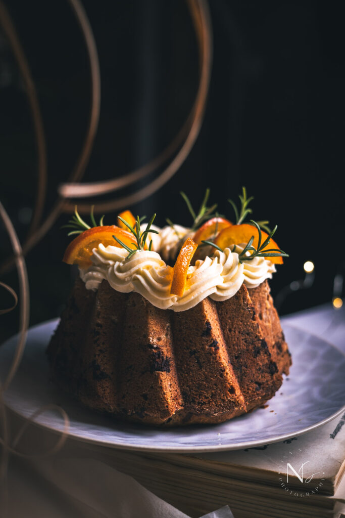 Richly flavored spice cake with a golden glaze and candied orange slices, perfect for Christmas gatherings.